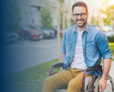 Na zdjęciu uśmiechnięty mężczyzna na wózku inwalidzkim