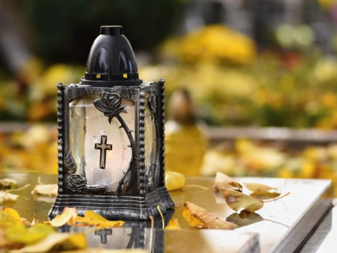 Na zdjęciu znicz ustawiony na nagrobku